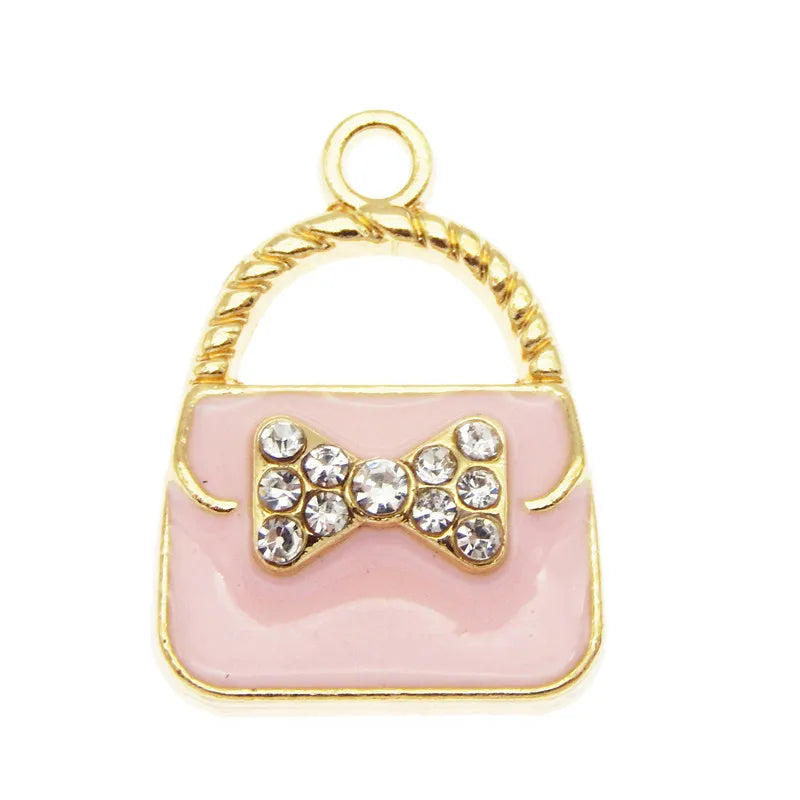 A set of six crystal enamel handbag charm pendants featuring a gold-toned loop and a pink square with a bow detail.