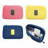 Three compact travel cable organizer bags in pink, yellow, and blue.