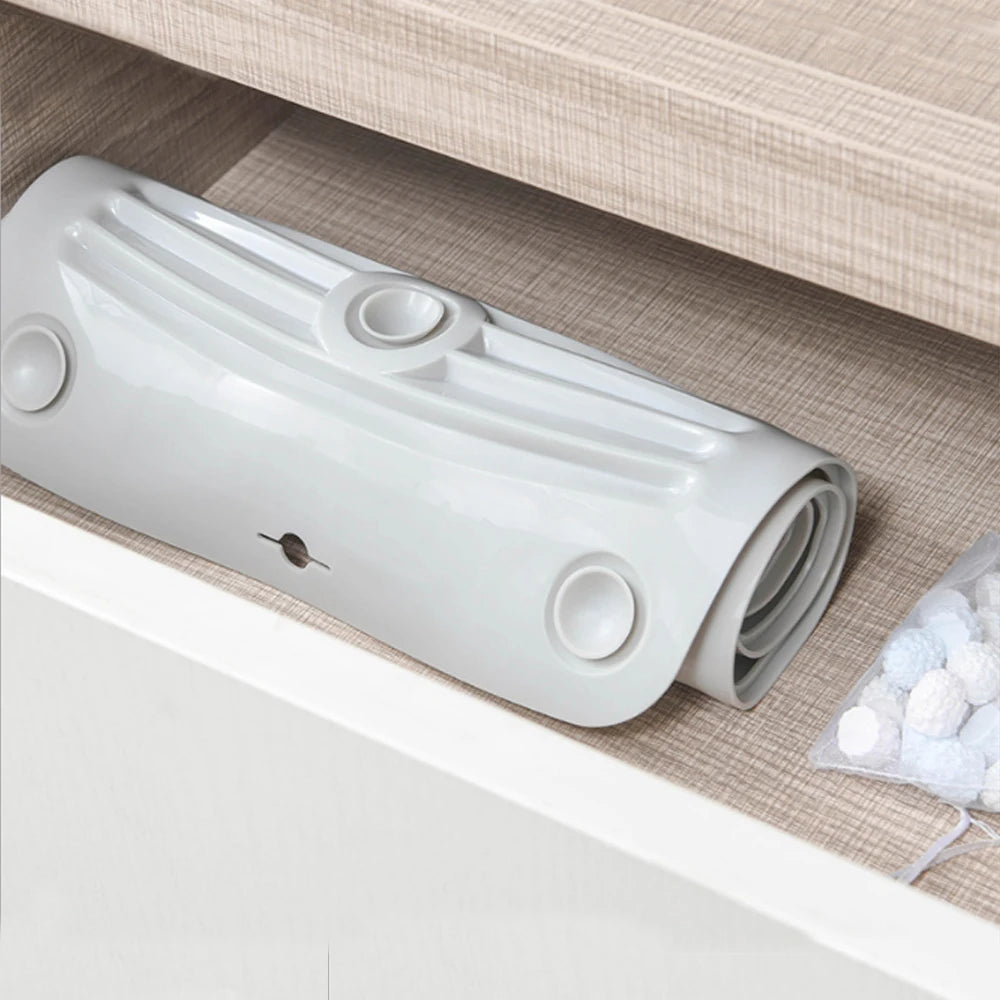 A white foldable silicone washboard with suction cups is shown resting in a drawer or cabinet.