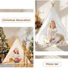 A girl sits inside a white fabric play tent with curtains, decorated for Christmas, surrounded by soft lighting and natural e