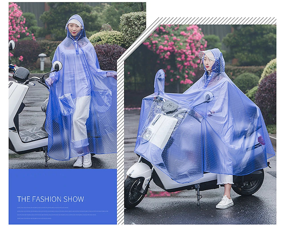A woman wearing a transparent blue waterproof motorcycle rain poncho with a hood riding a white scooter outdoors.