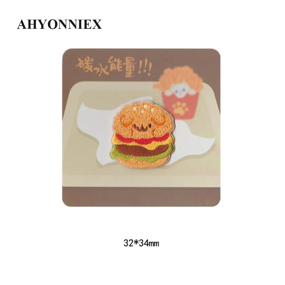 An embroidered iron-on patch featuring a cute hamburger design on a light brown background.