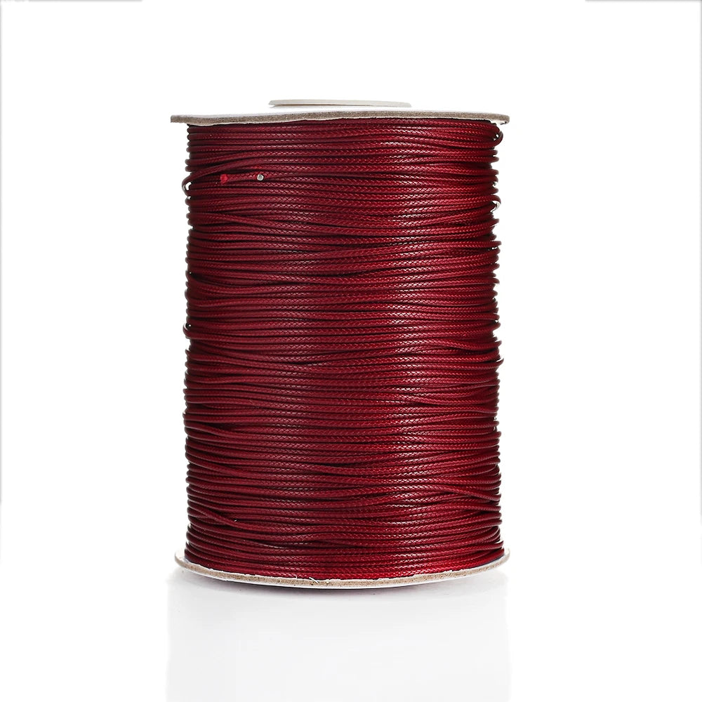 A spool of red waxed cotton cord used for jewelry making.