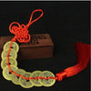 A necklace made of gold coins tied with a red handmade knot, used for Chinese Feng Shui wealth.