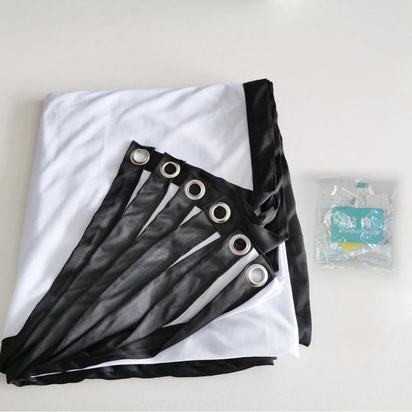 A black fabric screen is folded and displayed on a white surface, with several silver grommets visible.