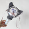 A plush cover for a light stick featuring gray fur and a clear dome displaying a purple crystal.