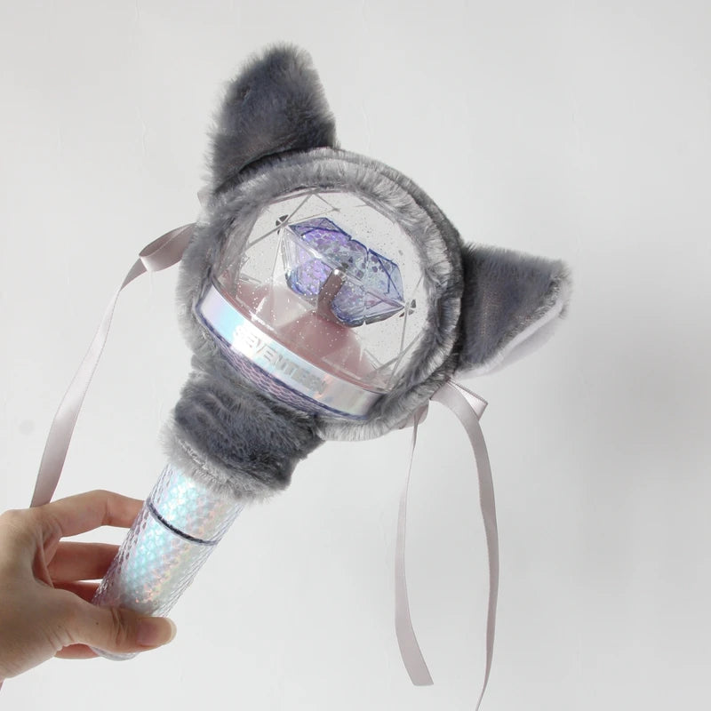 A plush cover for a light stick featuring gray fur and a clear dome displaying a purple crystal.