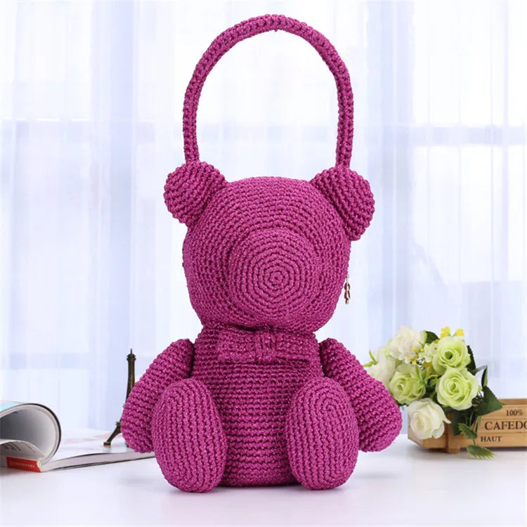 A handmade purple crochet teddy bear made from metallic silk yarn for knitting and macrame.