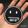 Black embroidered punk skull patch with a mouth showing teeth and the text SHUT UP on a hand
