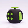 A black fidget cube with a lime green top and four round green buttons.