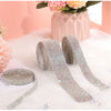 Silver crystal rhinestone ribbon stickers rolled and unrolled on a white fluffy surface