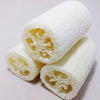 A roll of white natural loofah scrubber sponges shown from the side, revealing the porous texture.