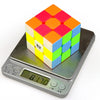 A colorful 3x3 speed cube puzzle resting on a digital scale.