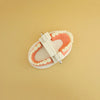 A white Montessori busy board accessory kit featuring a pink wooden tooth shape for toddler learning.