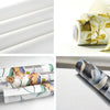 Rolls of blue vintage damask floral peel and stick wallpaper shown in various applications.
