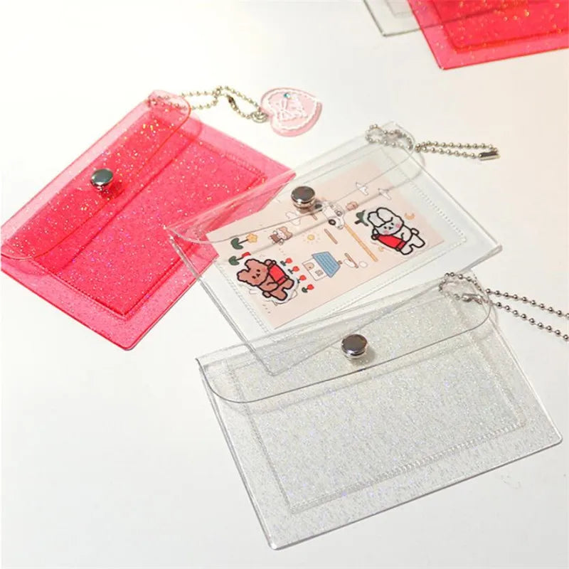 A set of clear and pink glitter PVC card holders with attached chains