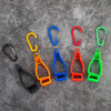 A collection of colorful durable glove clips in various shapes and sizes displayed on a gray surface.