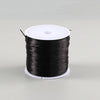 A spool of black elastic crystal beading cord for jewelry making with a white plastic core.