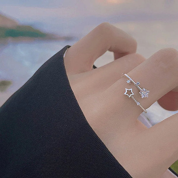 Primer plano de una mano vistiendo un anillo de estrella de plata esterlina ajustable con un pequeño diseño de estrella y cop