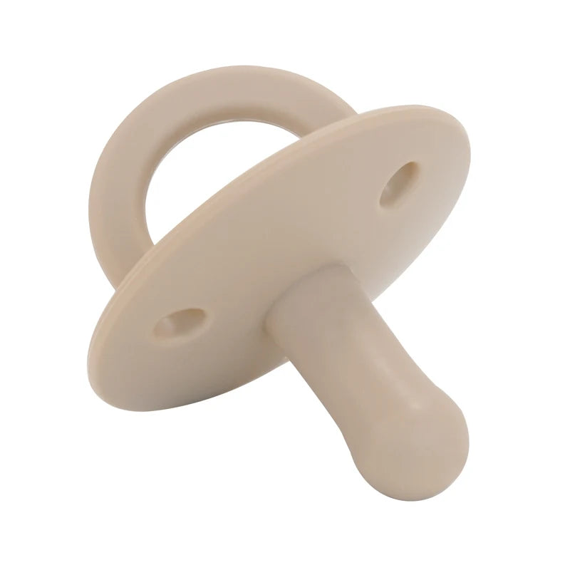 A beige silicone baby pacifier soother with a ring and a handle.
