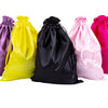 Fünf Satin-Aufbewahrungstaschen in lila, gelb, schwarz, rosa und magenta vor weißem Hintergrund.