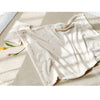 A cream-colored coral fleece baby blanket with subtle bear embroidery draped on a light surface.