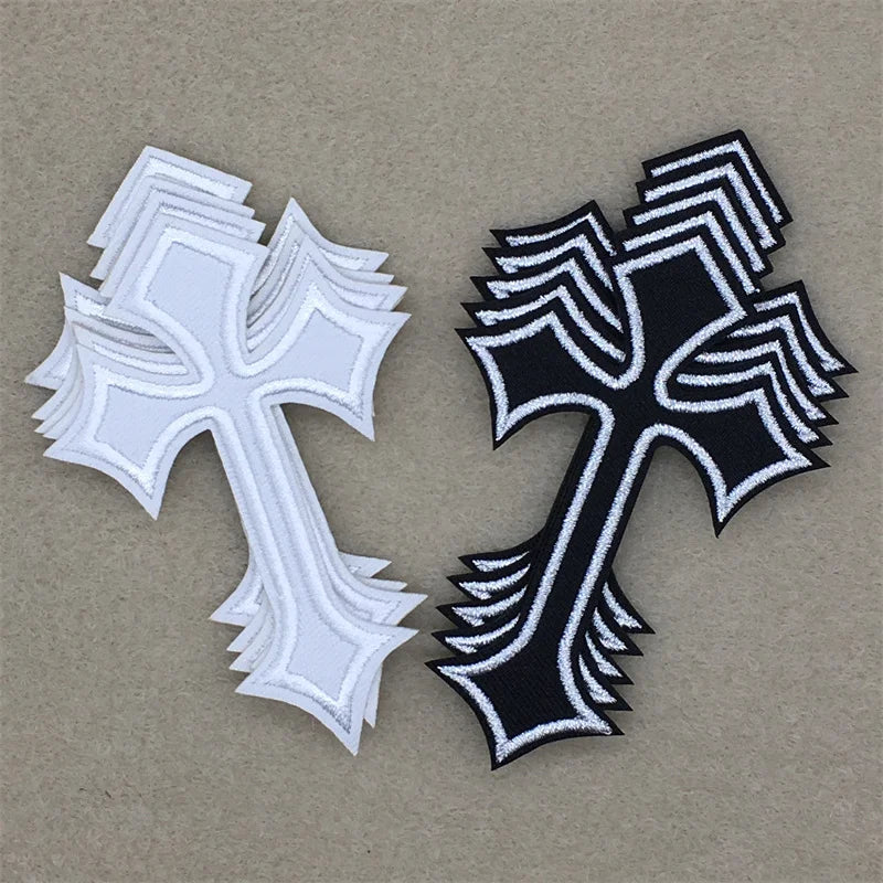 A set of two embroidered cross iron-on patches, one white and one black, displayed on a neutral background.