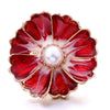 A red and white floral enamel button with a pearl center, featuring gold-toned metal edges.