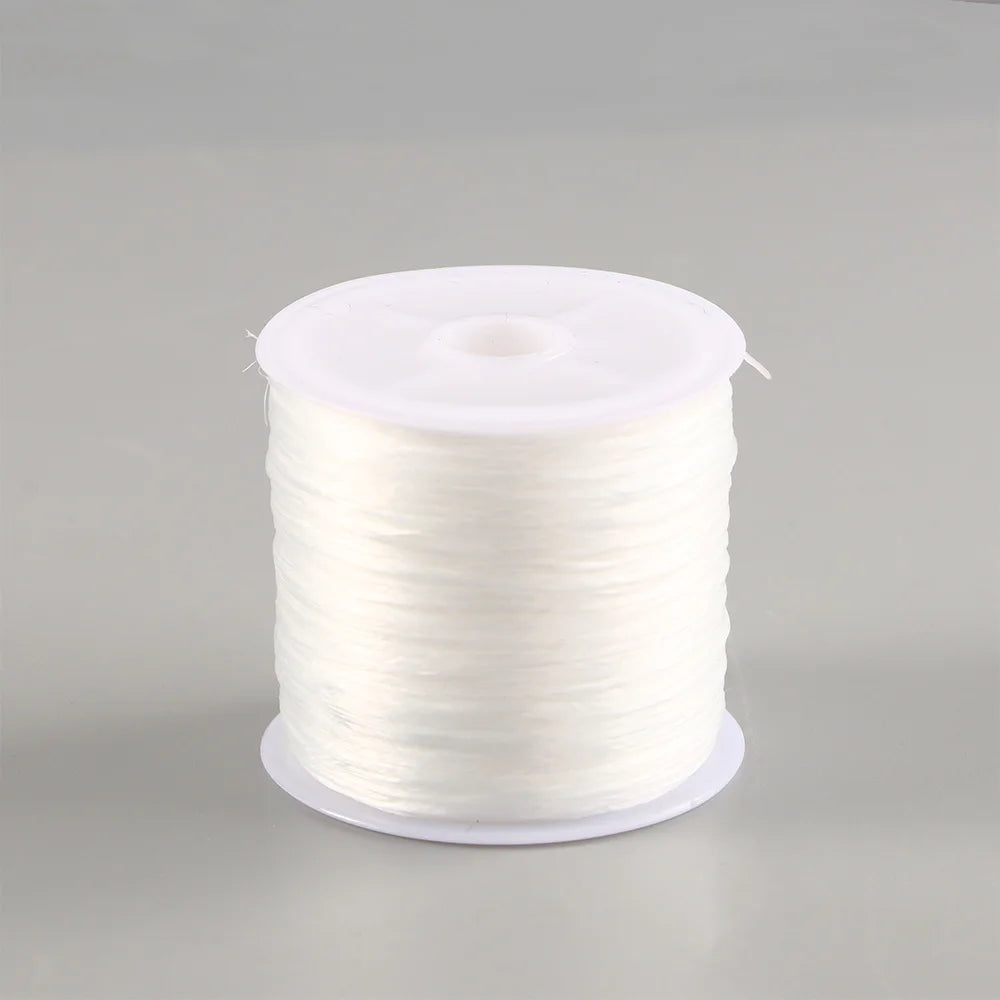 A spool of white elastic crystal beading cord for jewelry making.