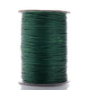 A spool of dark green waxed cotton cord used for jewelry making.
