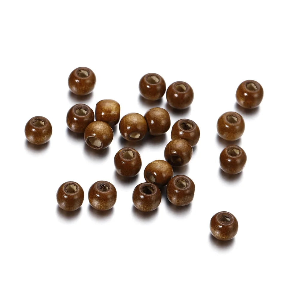 A collection of small, natural wooden spacer beads in various shades of brown scattered on a white background.