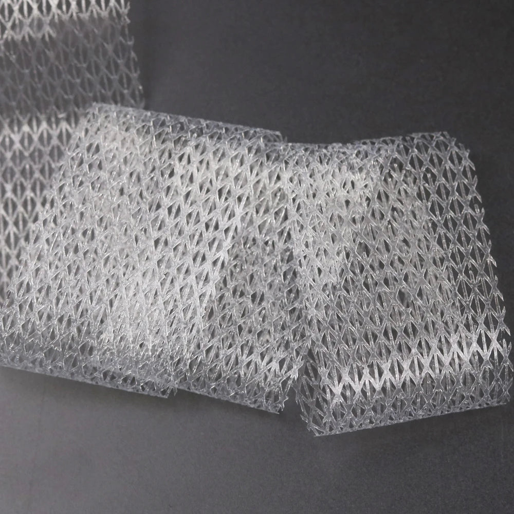 Rouleaux de ruban de couture à fer transparent pour un assemblage rapide de tissu, empilés sur une surface sombre.