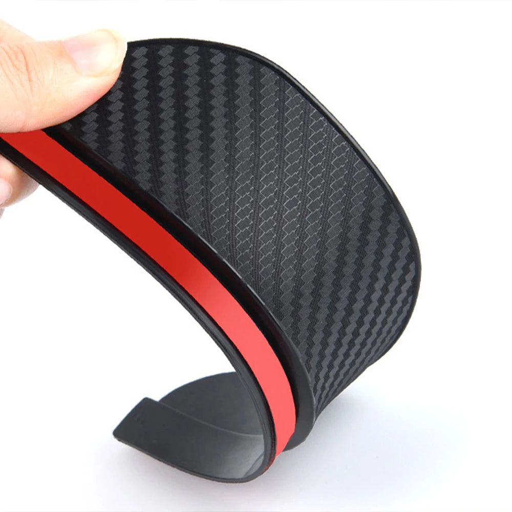 A black textured rain guard mirror visor with a red accent is shown being held.