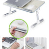 An adjustable foldable laptop desk with a built-in mouse, shown in use on a table.