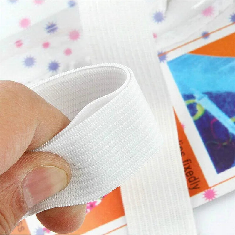 A hand is gripping a white adjustable bed sheet gripper with strong clips, shown next to colorful packaging.