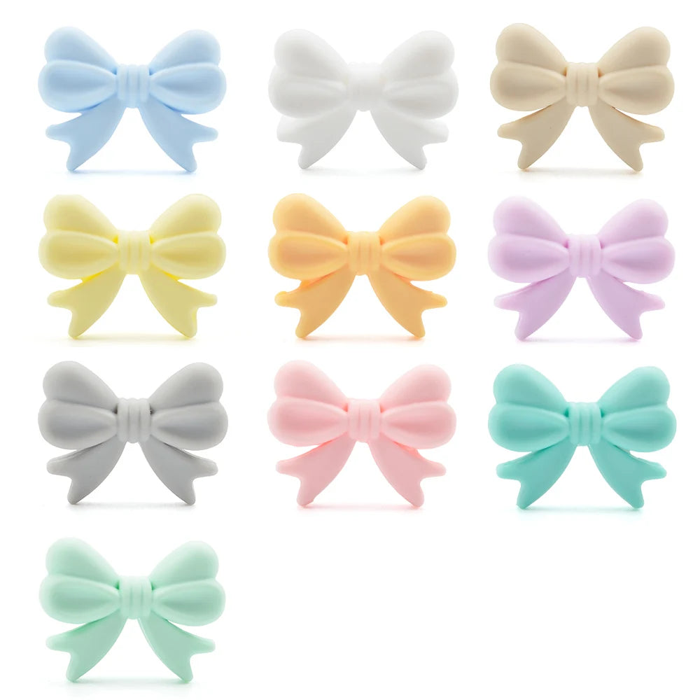 A collection of twelve food-grade silicone crown beads in various pastel colors including blue, white, yellow, orange, purple