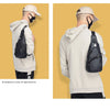 A man wearing a beige hoodie and cap is shown in two views, featuring a black leather chest bag.