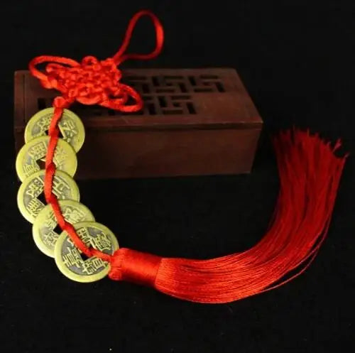 Chinese Feng Shui wealth coins strung together with a red handmade knot and tassel