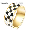 A gold-toned chunky ring with a black and white checkerboard pattern, showing its size and weight.