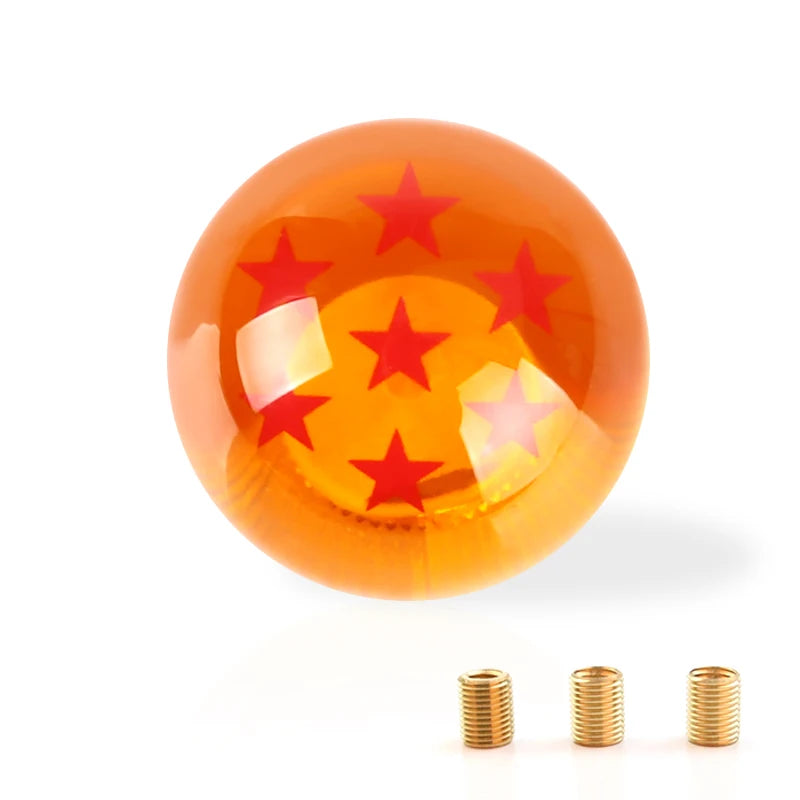A glossy orange shift knob with a star design is shown next to several small brass rings.