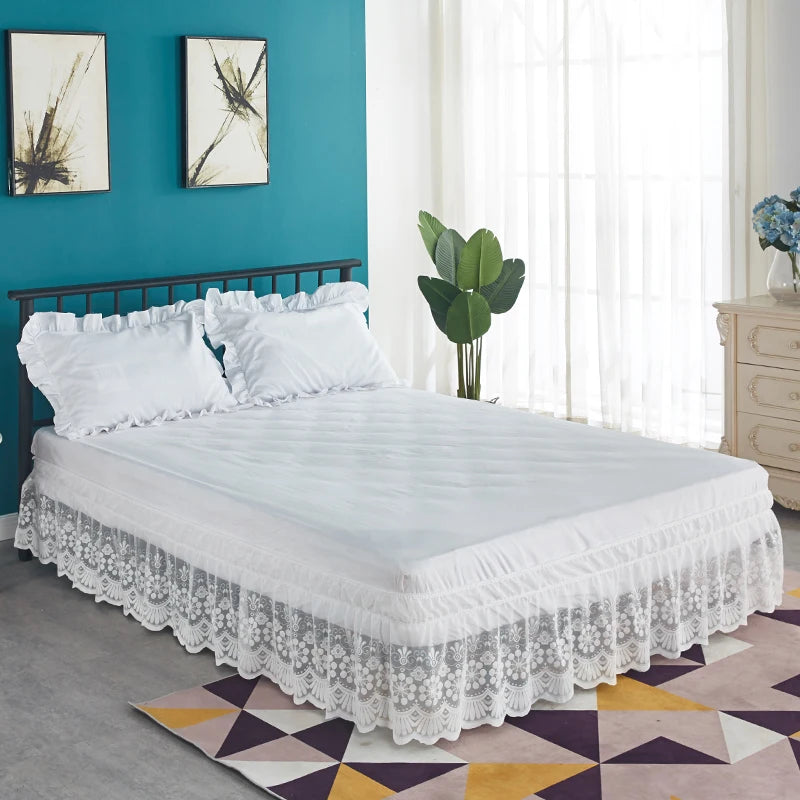White ruffled lace bed skirt on a bed with a dark headboard and teal accent wall.