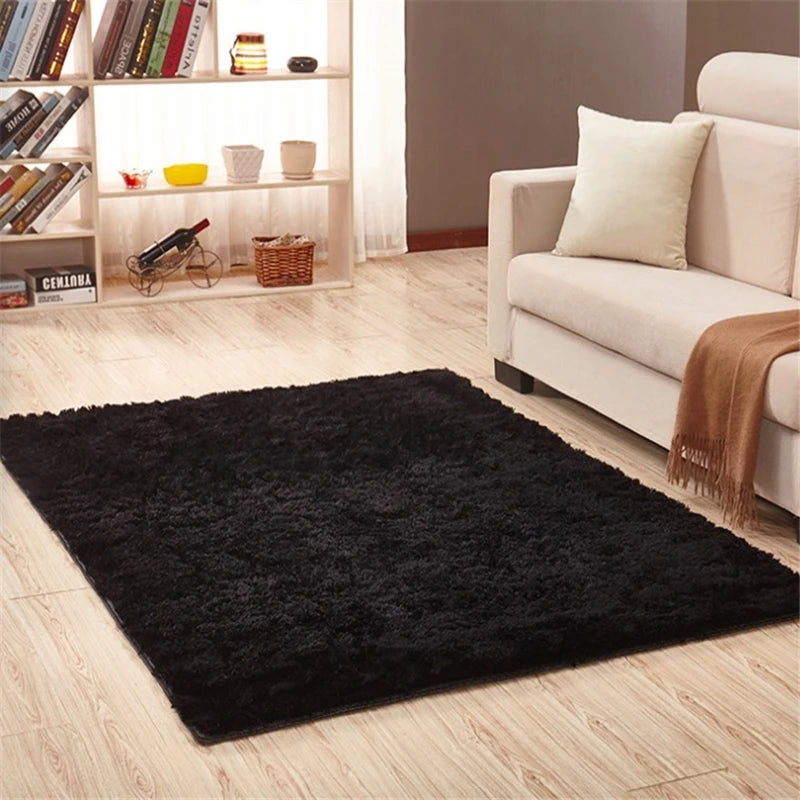 Alfombra anti-resbalante negra de peluche sobre suelo de madera clara en un espacio moderno.
