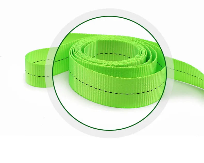 A close-up view of a roll of bright lime green heavy-duty tie-down straps with black dashed lines.