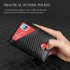 A hand holds a black carbon fiber wallet with a thumb opening for quick payments.