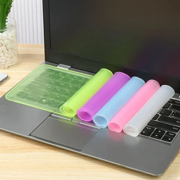 A laptop keyboard is shown with multiple colored silicone covers placed on the keys.