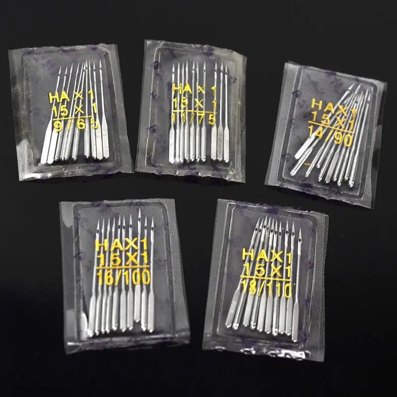 A collection of silver sewing machine needles packaged in clear plastic trays with various sizes and counts.