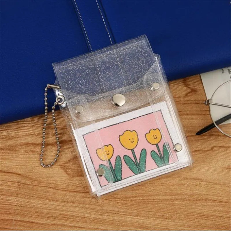 A clear glitter card holder with a pink background featuring yellow flowers rests on a wooden surface.