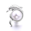 Silver metal snap button shaped like a tiny shrimp with a round pearl center for jewelry making