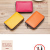 Two genuine leather card holders, one pink and one orange, displayed on a wooden surface.