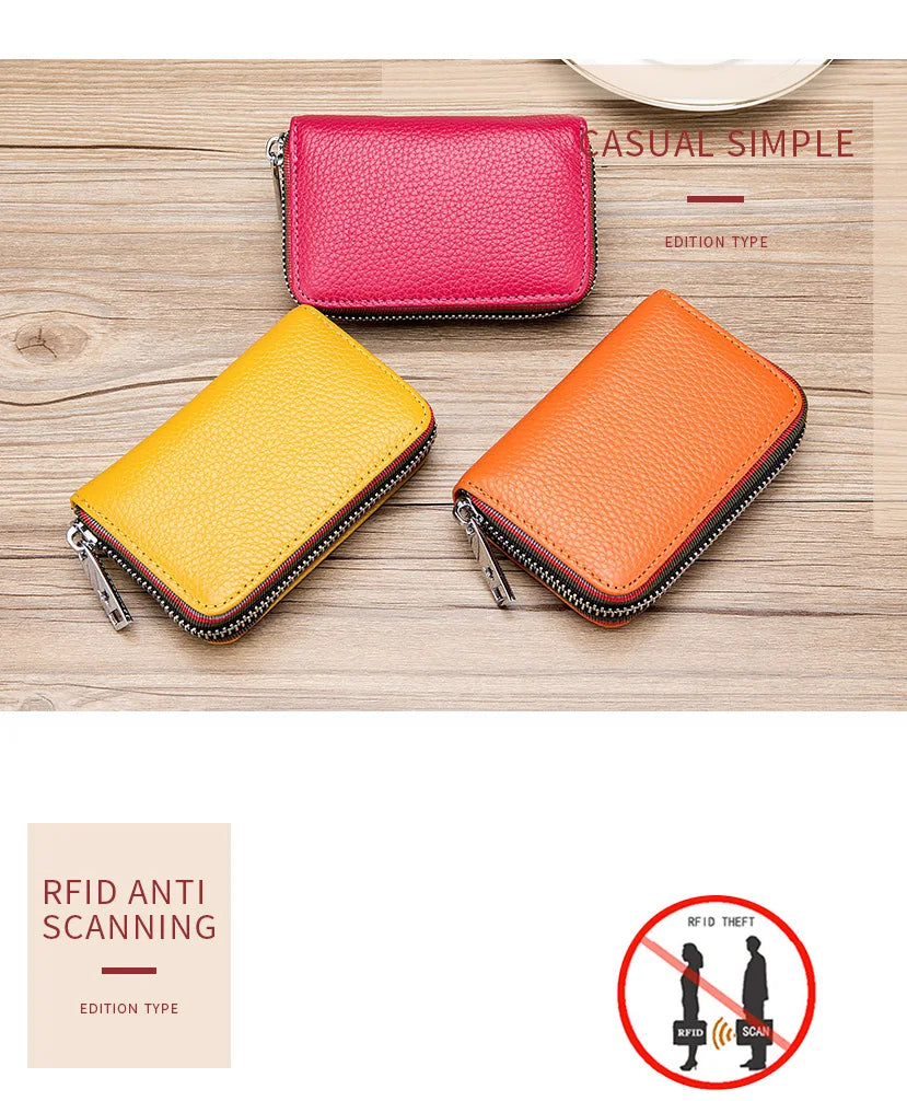Two genuine leather card holders, one pink and one orange, displayed on a wooden surface.